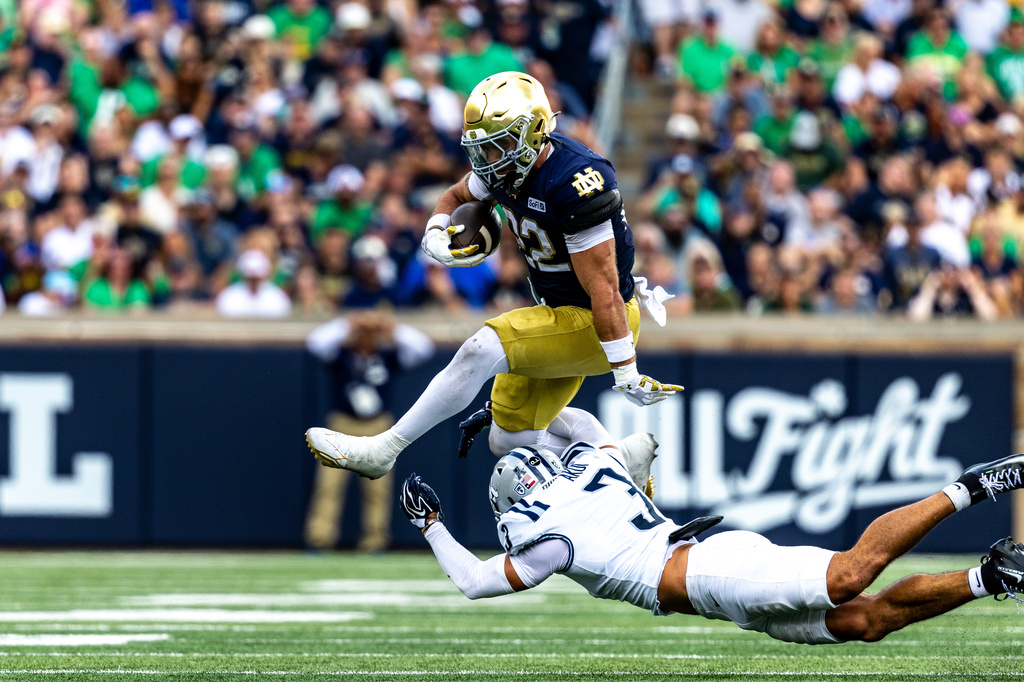 Notre Dame running back Aneyas Williams, top, jumps over Rice safety Koa Akui (3) during the first half of an NCAA college football game, Saturday, Sept. 12, 2026, in South Bend, Ind. (AP Photo/Paul Barnick)