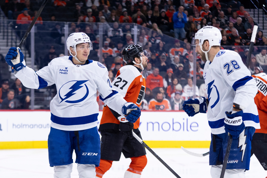 Tampa Bay Lightning's Pontus Holmberg, left, reacts to his goal with Zemgus Girgensons, right, as Philadelphia Flyers' Noah Cates, center, skates by during the first period of an NHL hockey game, Monday, Jan. 12, 2026, in Philadelphia. (AP Photo/Chris Szagola)