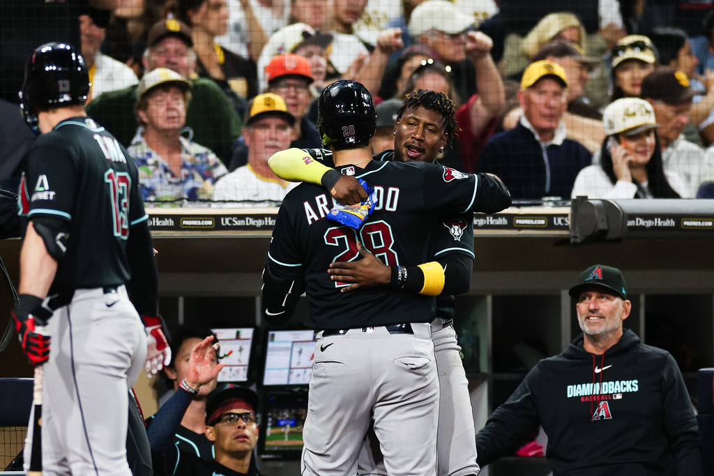 Arizona Diamondbacks' Geraldo Perdomo, second from right, congratulates Nolan Arenado (28) as manager Torey Lovullo, right, watches after Arenado hit a solo home run against the San Diego Padres in the sixth inning of a baseball game Thursday, July 9, 2026, in San Diego. (AP Photo/Derrick Tuskan)