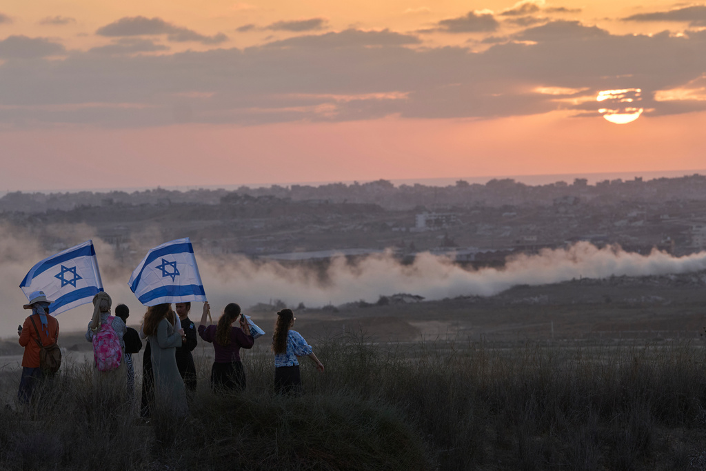 Israeli right-wing activists watch the northern Gaza Strip during a rally calling for the re-establishment of Jewish settlements in the Gaza Strip, near the border in southern Israel, Wednesday, July 30, 2025. (AP Photo/Ohad Zwigenberg)
