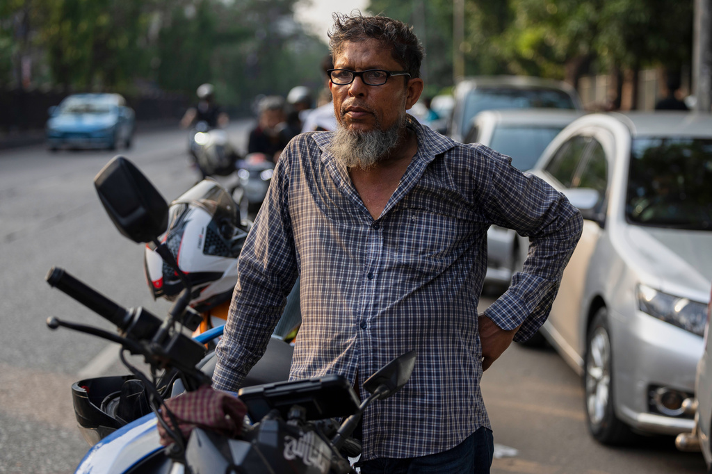 Tariqul Islam, a ride-share driver, waits in a long queue of petrol for his motorcycle in Dhaka, Bangladesh, Tuesday, April 23, 2026. (AP Photo/Abdul Goni)