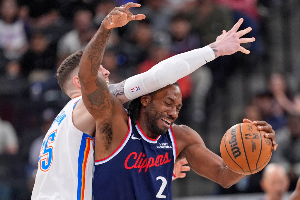 Oklahoma City Thunder center Isaiah Hartenstein, left, reaches over Los Angeles Clippers forward Kawhi Leonard during the first half of an NBA basketball game Wednesday, April 8, 2026, in Inglewood, Calif. (AP Photo/Mark J. Terrill)