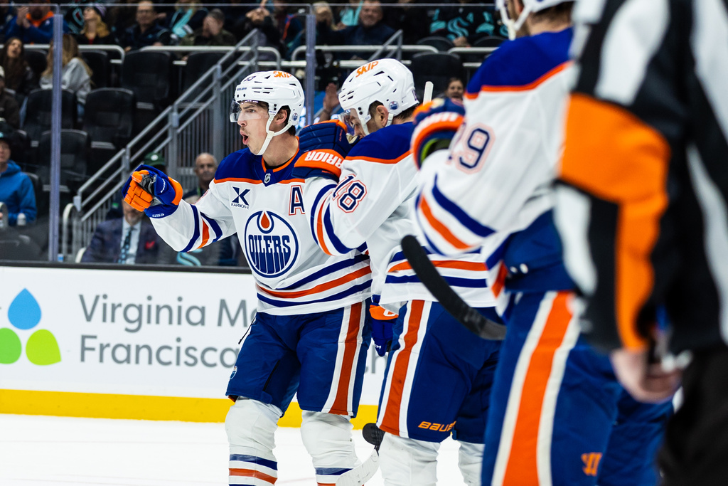 Edmonton Oilers center Ryan Nugent-Hopkins, left, celebrates after scoring a goal during the first period of an NHL hockey game against the Seattle Kraken, Saturday, Nov. 29, 2025, in Seattle. (AP Photo/Maddy Grassy)