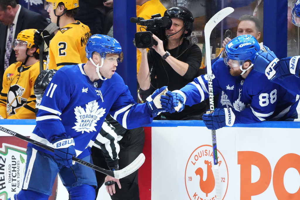 Toronto Maple Leafs forward Max Domi (11) celebrates his goal against the Pittsburgh Penguins with forward William Nylander (88) during the third period of an NHL hockey game in Toronto, Tuesday, Dec. 23, 2025. (Nathan Denette/The Canadian Press via AP)