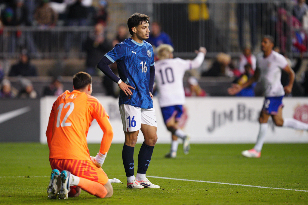 Paraguay's Orlando Gill, left, and Damián Bobadilla (16) react after a goal scored by United States' Folarin Balogun during the second half of an international friendly soccer match, Saturday, Nov. 15, 2025, in Chester, Pa. (AP Photo/Derik Hamilton)