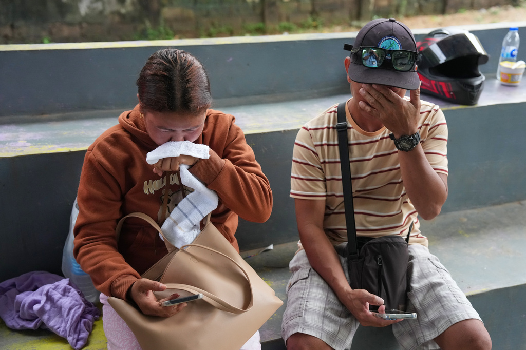 Lira Daco, left, wipes tears beside husband Menandro as they wait for news of their missing daughter in Coron, Palawan province, western Philippines, Friday Sept. 11, 2026, days after the ferry MV June Aster caught fire off Coron. (AP Photo/Aaron Favila)