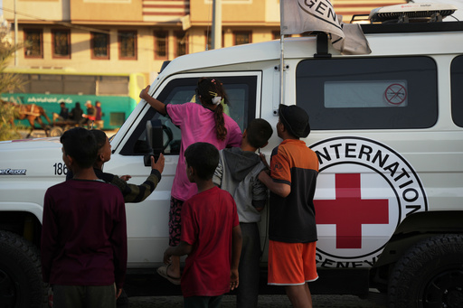 Palestinian kids look into a Red Cross vehicles carrying the bodies of two people believed to be deceased hostages handed over by Hamas make their way toward the Kissufim border crossing with Israel, to be transferred to Israeli authorities, in Deir al-Balah, central Gaza Strip, Thursday, Oct. 30, 2025. (AP Photo/Abdel Kareem Hana) Palestinian kids look into a Red Cross vehicles carrying the bodies of two people believed to be deceased hostages handed over by Hamas make their way toward the Kissufim border crossing with Israel, to be transferred to Israeli authorities, in Deir al-Balah, central Gaza Strip, Thursday, Oct. 30, 2025. (AP Photo/Abdel Kareem Hana)