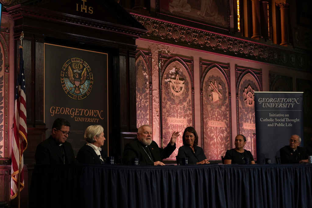 FILE - The archbishop of Miami, Thomas Wenski, raises his hand while addressing a crowd during a panel on immigration at Georgetown University in Washington, Thursday, Sept. 11, 2025. (AP Photo/Luis Andres Henao,File)