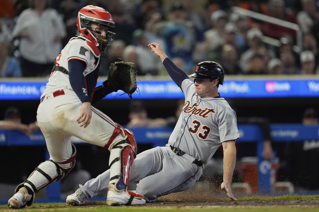 Detroit Tigers' Colt Keith (33) slides past Minnesota Twins catcher Ryan Jeffers, left, to score during the 11th inning of a baseball game Thursday, Aug. 14, 2025, in Minneapolis. (AP Photo/Abbie Parr)