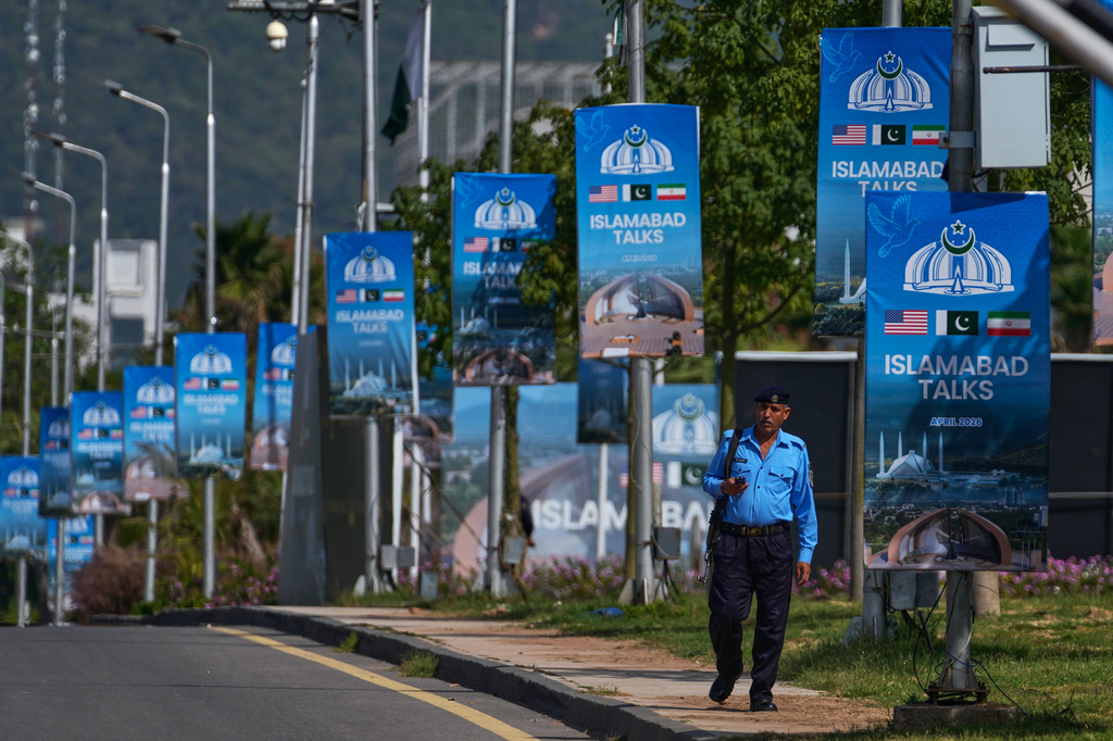 A police officer walks past billboards near the Serena Hotel ahead of the second round of negotiations between the U.S. and Iran, in Islamabad, Pakistan, Tuesday, April 21, 2026. (AP Photo/Anjum Naveed)