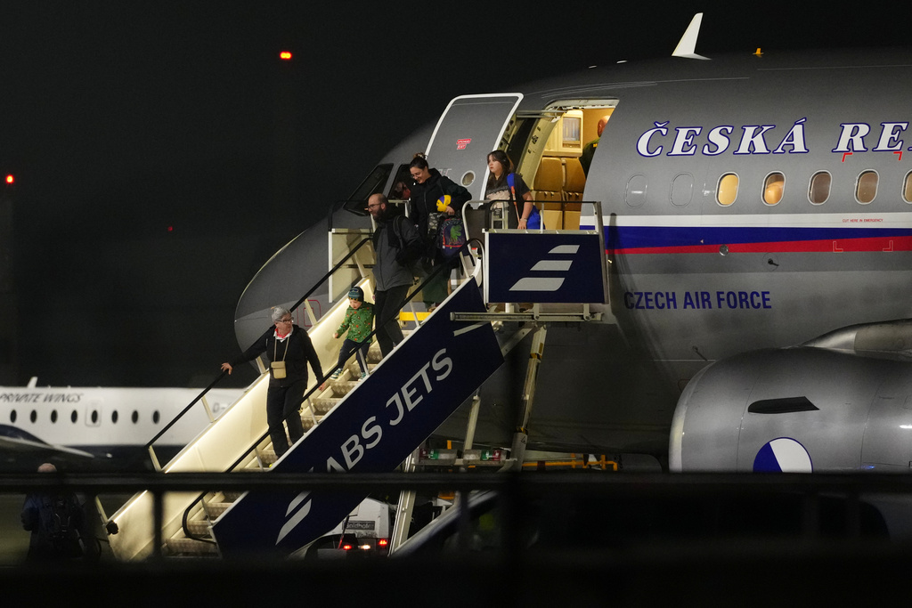 People arrive at the airport after being evacuated from the Middle East on a government flight, in Prague, Czech Republic, Tuesday, March 3, 2026. (AP Photo/Petr David Josek)