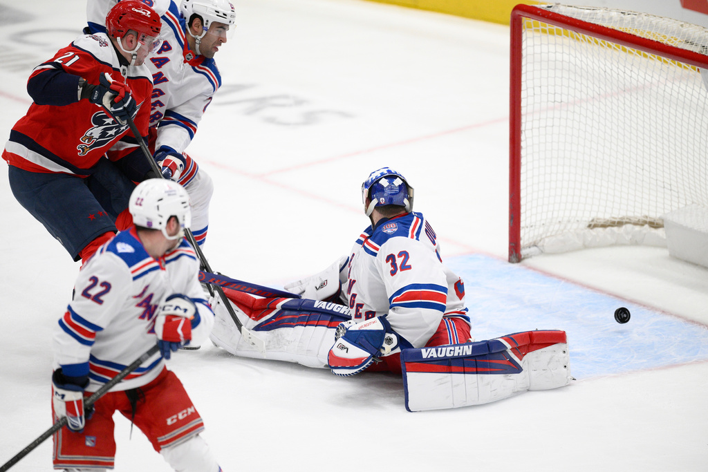 Washington Capitals center Aliaksei Protas (21) scores a goal past New York Rangers goaltender Jonathan Quick (32) during the third period of an NHL hockey game, Wednesday, Dec. 31, 2025, in Washington. (AP Photo/Nick Wass)