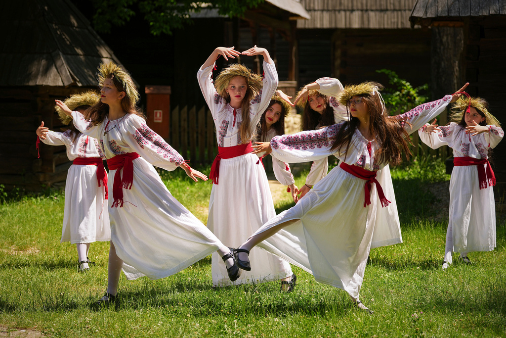 Girls, wearing crowns made of flowers, dance during the 'Sanziene' midsummer festival at the Dimitrie Gusti Village Museum, in Bucharest, Romania, June 24, 2025. (AP Photo/Andreea Alexandru, File)