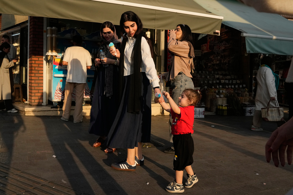 People walk on a sidewalk in northern Tehran, Wednesday, June 10, 2026. (AP Photo/Vahid Salemi)