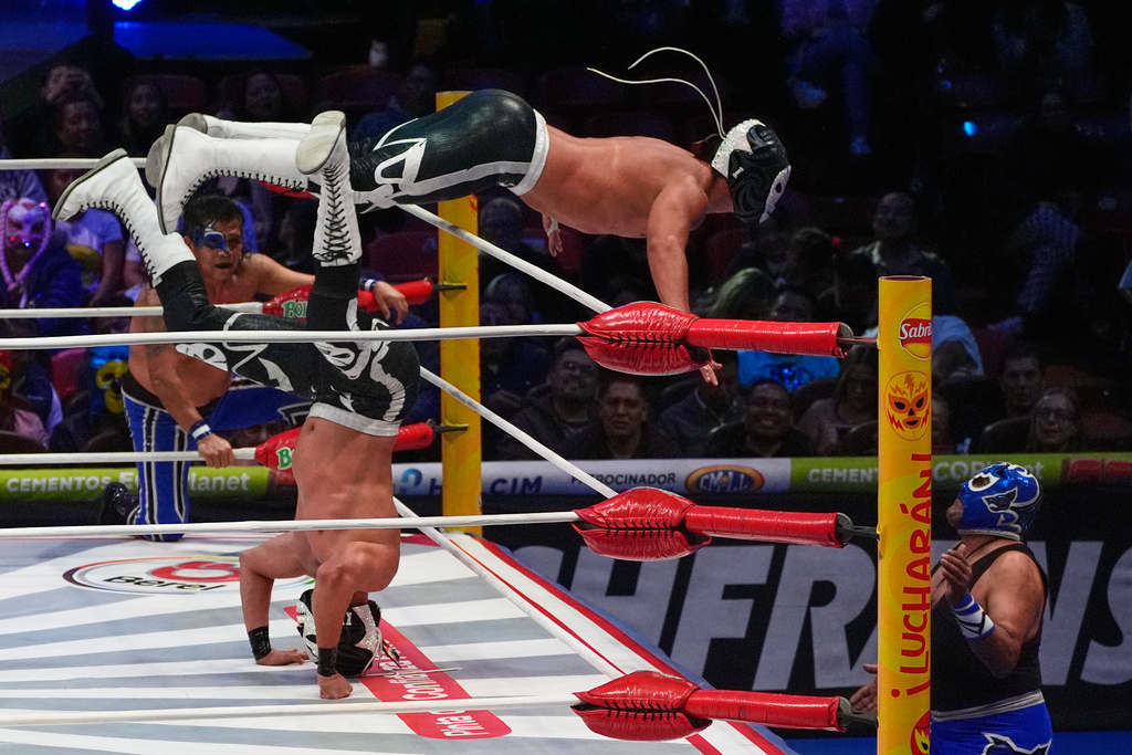 Lucha Libre wrestlers Calavera Jr. I and Calavera Jr. II fight at the Arena Mexico in Mexico City, Friday, Feb. 6, 2026. (AP Photo/Marco Ugarte)