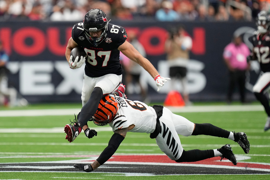 Houston Texans tight end Foster Moreau (87) runs with the ball as Cincinnati Bengals safety Bryan Cook (6) tries to tackle during the first half of an NFL football game in Houston, Sunday, Sept. 20, 2026. (AP Photo/Ashley Landis)