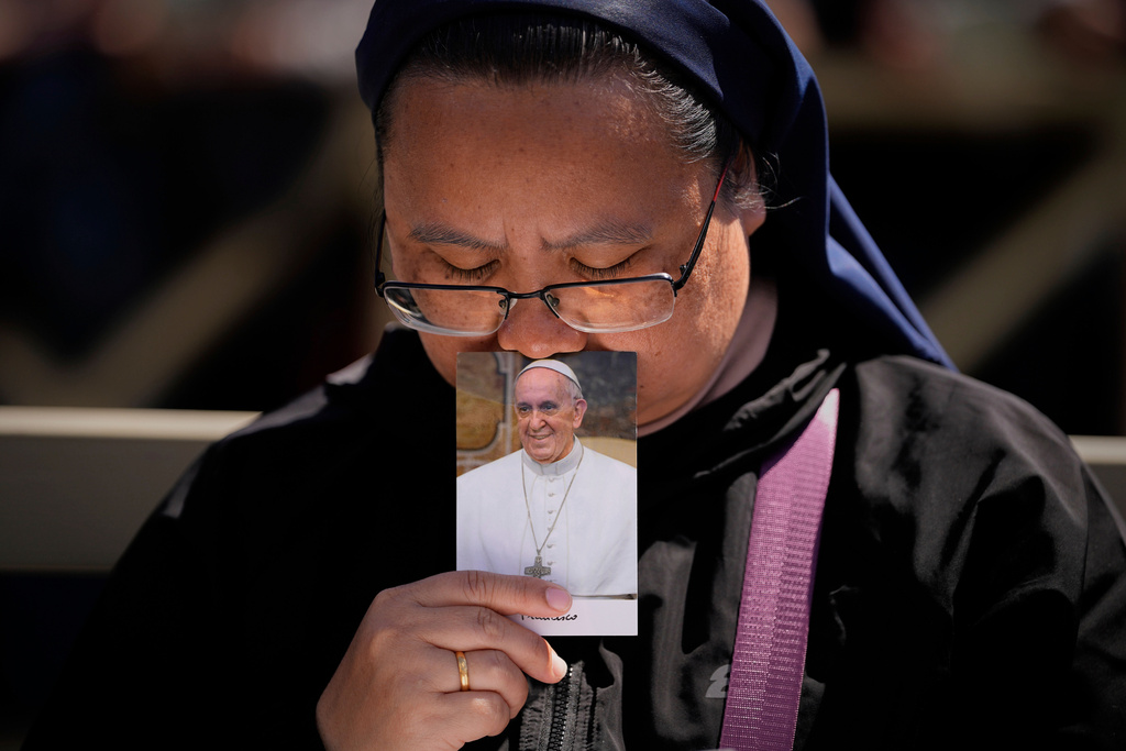 A nun holds a photo of Pope Francis while attending his funeral, in St. Peter's Square at the Vatican, April 26, 2025. (AP Photo/Andreea Alexandru, File)