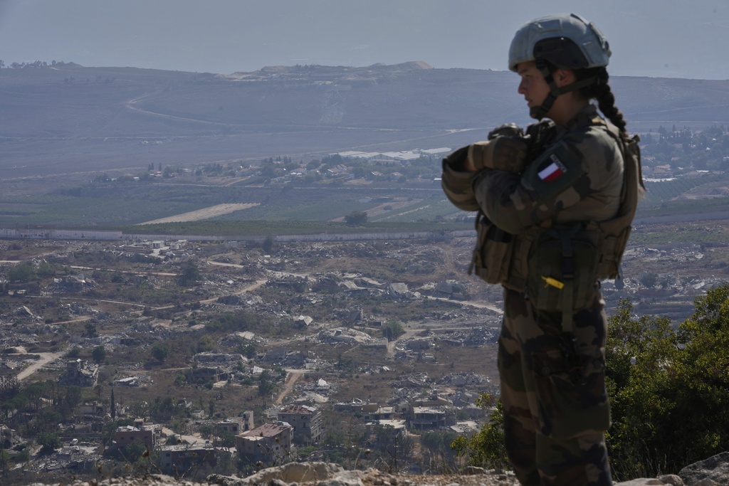 A French U.N. peacekeeper stands on a hill overlooking Kfar Kila, a Lebanese border village destroyed by Israeli airstrikes and a ground offensive, in south Lebanon, Wednesday, Aug. 20, 2025. (AP Photo/Hussein Malla)