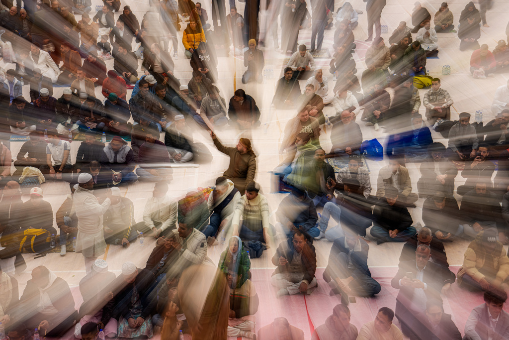 Muslims wait before Eid al-Fitr prayers in a sports hall in Bucharest, Romania, Friday, March 20, 2026. (AP Photo/Vadim Ghirda)