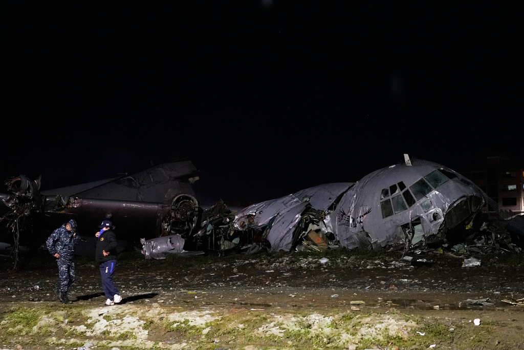 Police stands next to a plane that crashed in El Alto, Bolivia, Friday, Feb. 27, 2026. (AP Photo/Juan Karita)