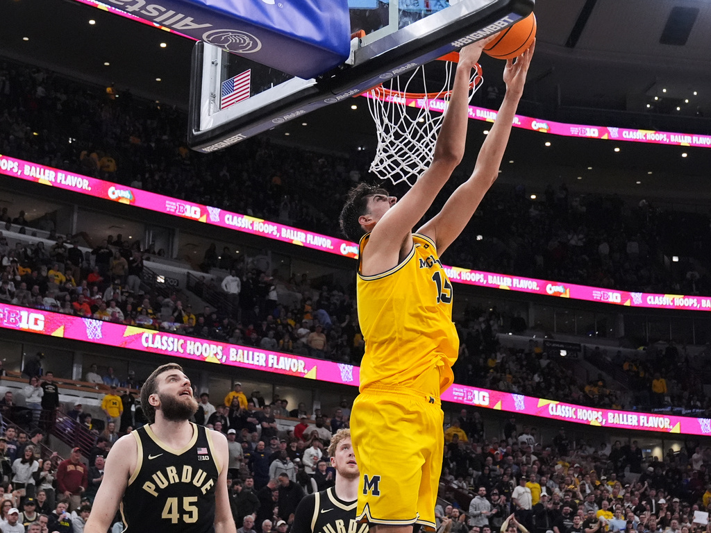 Michigan center Aday Mara, right, does a reverse dunk as Purdue center Oscar Cluff looks on during the second half of an NCAA college basketball game in the championship of the Big 10 Conference tournament, Sunday, March 15, 2026, in Chicago. (AP Photo/Nam Y. Huh)