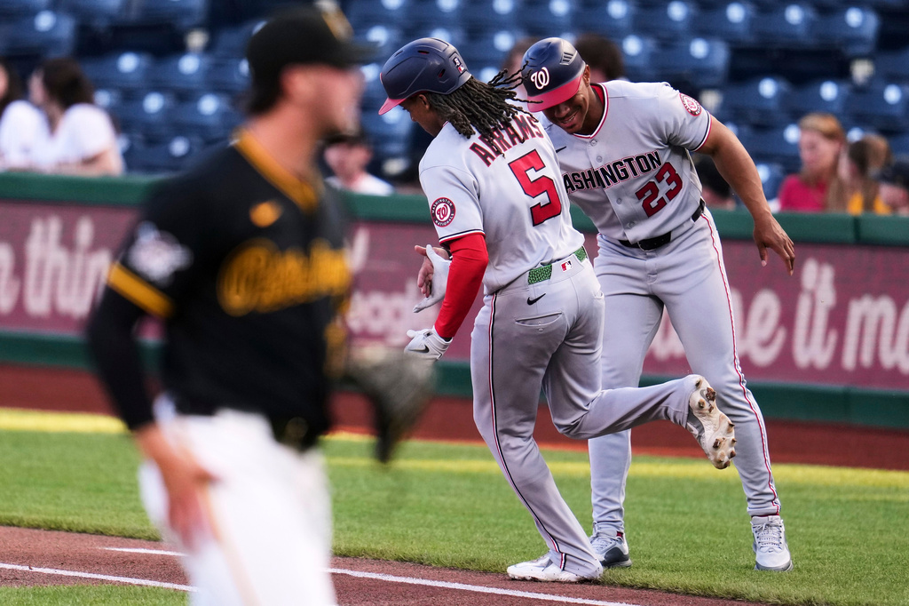 Washington Nationals' CJ Abrams (5) is greeted by first base coach Corey Ray (23) as he rounds first after hitting a solo home run off Pittsburgh Pirates pitcher Paul Skenes, left, during the first inning of a baseball game in Pittsburgh, Monday, April 13, 2026. (AP Photo/Gene J. Puskar)