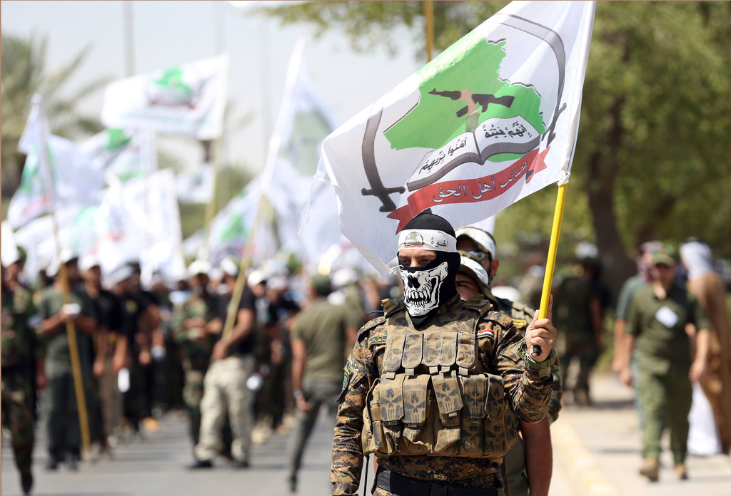 FILE - Members of the Iraqi Popular Mobilization Forces parade of Shiite group Asaib Ahl al-Haq, participate in a Quds Day march in Baghdad, Iraq, Friday, July 1, 2016. (AP Photo/Hadi Mizban, File)