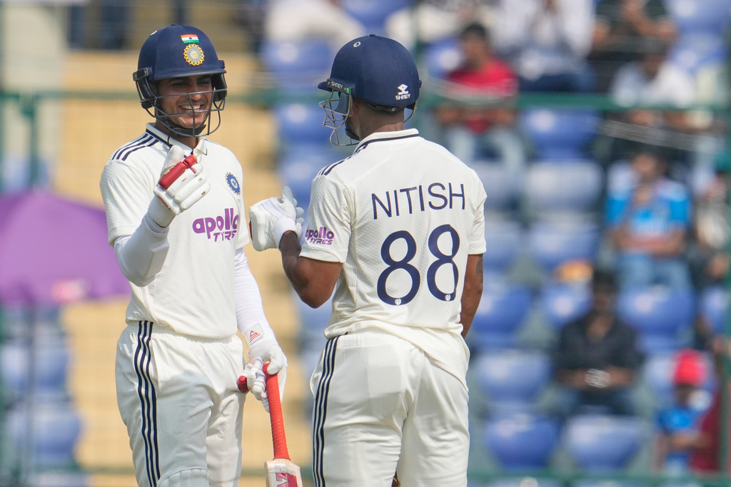 India's captain Shubman Gill gives the fist touch to Nitish Kumar Reddy after scoring runs on the second day of the second cricket test match between India and West Indies at the Arun Jaitley Stadium in New Delhi, India, Saturday, Oct.11, 2025. (AP Photo/Manish Swarup)