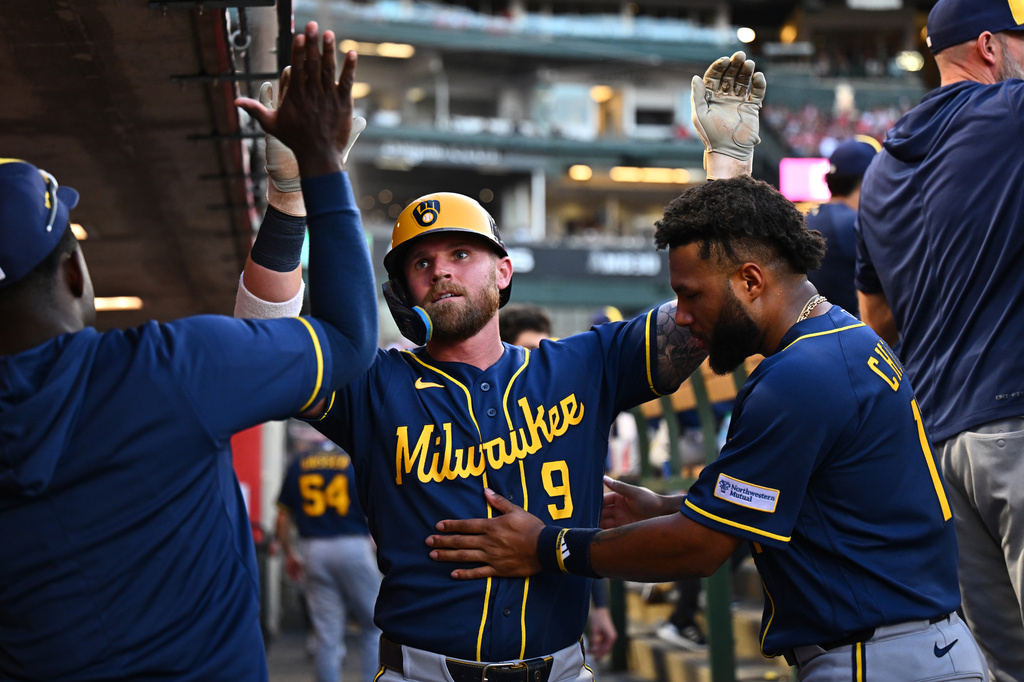 Milwaukee Brewers' Jake Bauers (9)is greeted by teammates after hitting a home run during the fourth inning of a baseball game against the Los Angeles Angels, Saturday, Aug. 1, 2026, in Anaheim, Calif. (AP Photo/William Liang)
