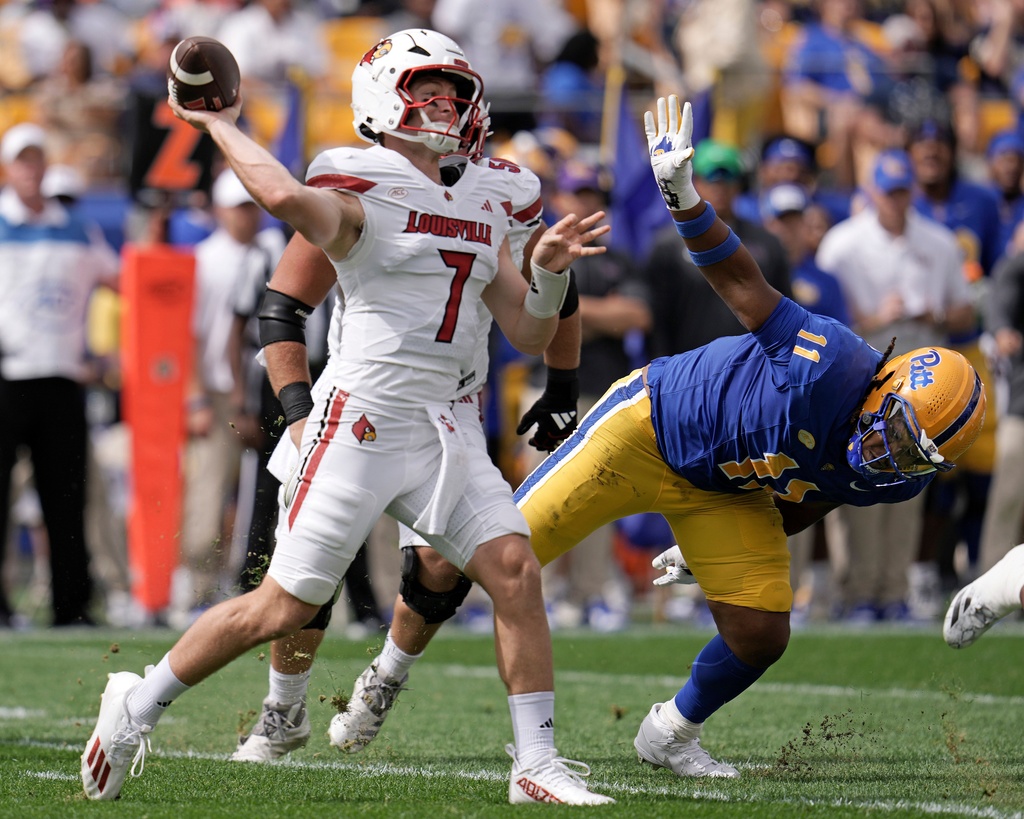 Louisville Cardinals quarterback Miller Moss (7) pass under pressure by Pittsburgh defensive lineman Nick James (11) during the first half of an NCAA college football game in Pittsburgh, Saturday, Sept. 27, 2025. (AP Photo/Gene J. Puskar)
