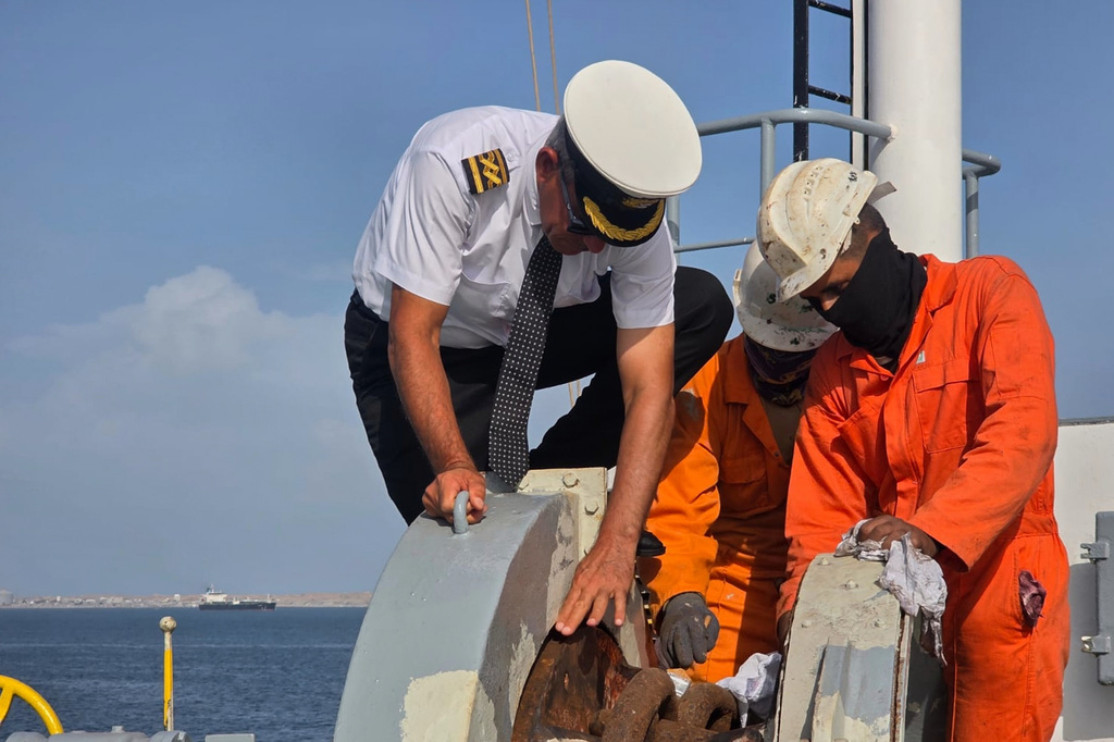 In this photo courtesy of Captain Rahman Al-Jubouri, left, he supervises sailors on the deck of the Sea Moon oil tanker on the waters the Gulf of Oman, Wednesday, April 15, 2026. (Photo courtesy of Capt. Rahman Al-Jubouri via AP)