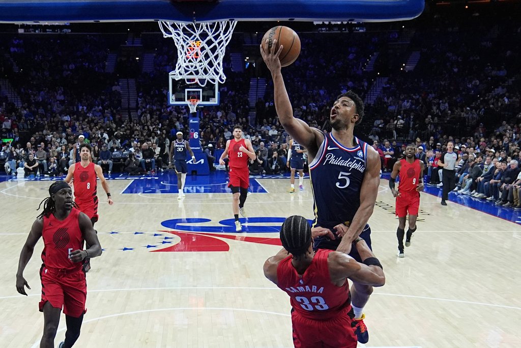 Philadelphia 76ers' Quentin Grimes (5) goes up to shoot against Portland Trail Blazers' Toumani Camara during the first half of an NBA basketball game Sunday, March 15, 2026, in Philadelphia. (AP Photo/Matt Rourke)