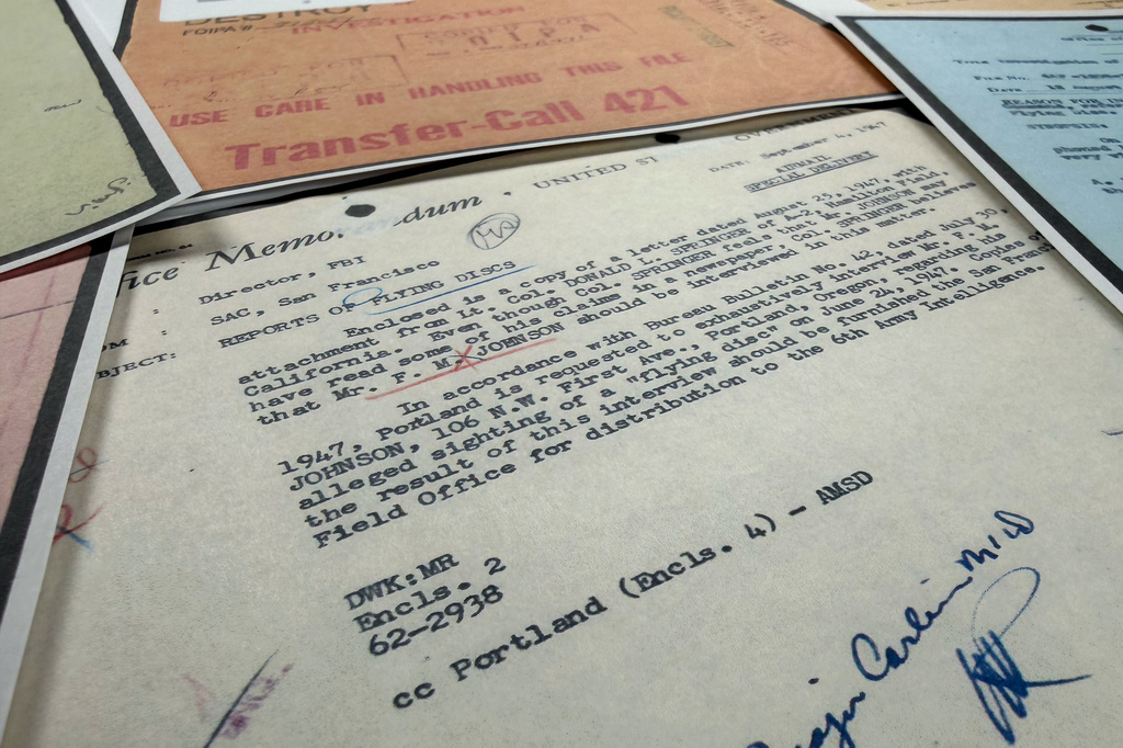 Files on UFOs, released Friday, May 8, 2026, by the Pentagon, are photographed in Washington. (AP Photo/Jon Elswick)
