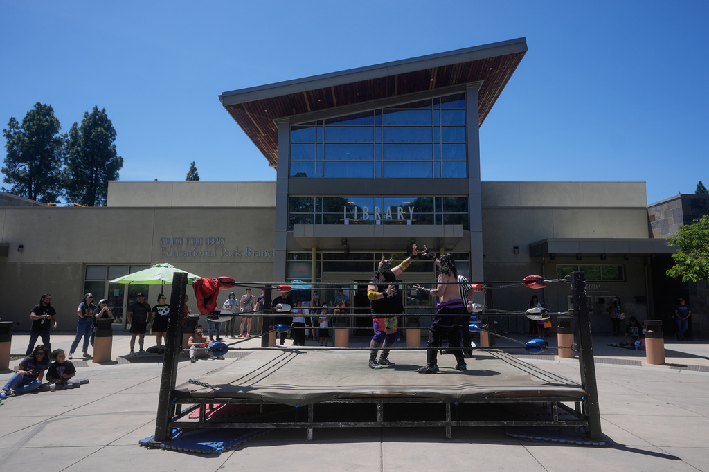 Wrestlers Llama Jack, center left, and Sampiro compete in a Lucha Libro pro wrestling match at the San Jose Public Library Educational Park Branch Saturday, May 9, 2026, in San Jose, Calif. (AP Photo/Jeff Chiu)