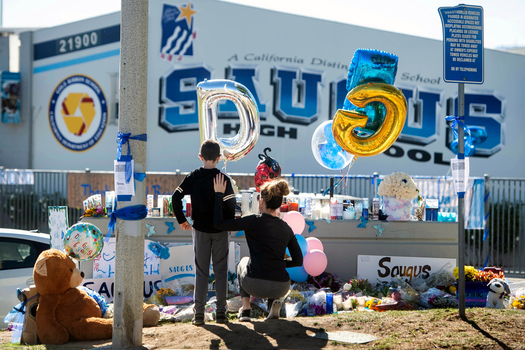 FILE - Michelle Bosshard and her son Lucas visit a memorial on Nov. 18, 2019, for two students killed during a shooting at Saugus High School in Santa Clarita, Calif., days before. (Sarah Reingewirtz/The Orange County Register via AP, File)