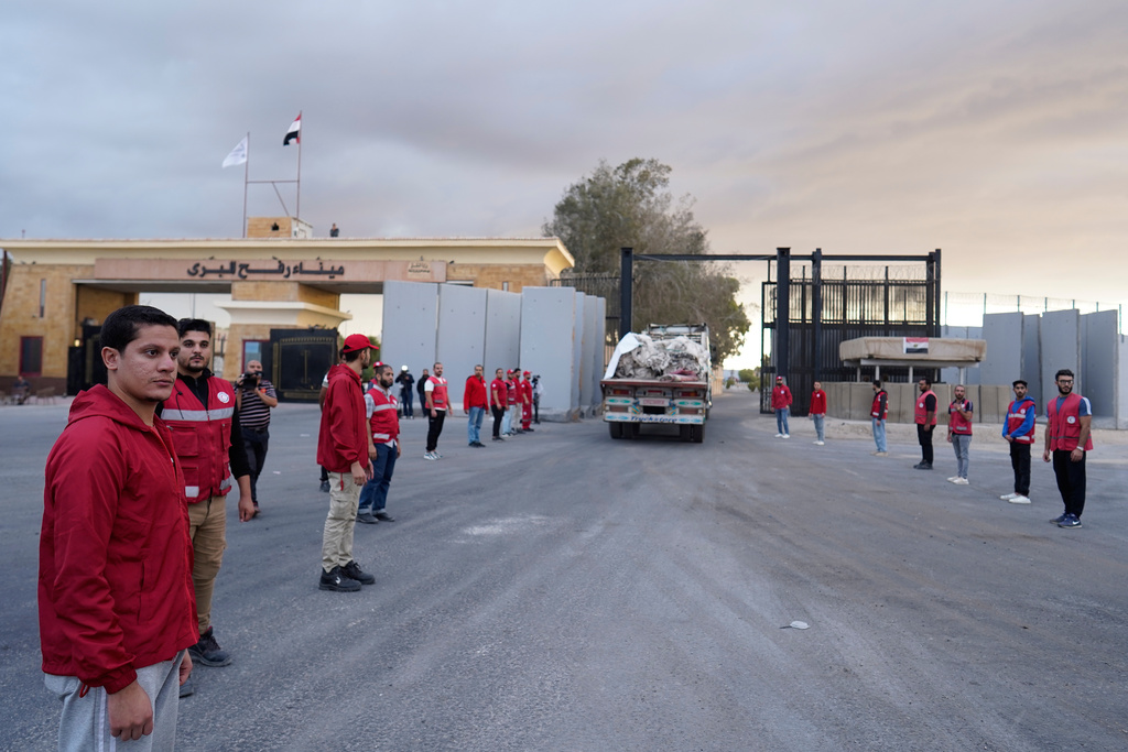 Egyptian Red Crecent members monitor a truck carrying humanitarian aids as it enters the Rafah crossing between Egypt and the Gaza Strip, following an agreement between Israel and Hamas on a ceasefire, Sunday, Oct. 12, 2025. (AP Photo/Mohamed Arafat)