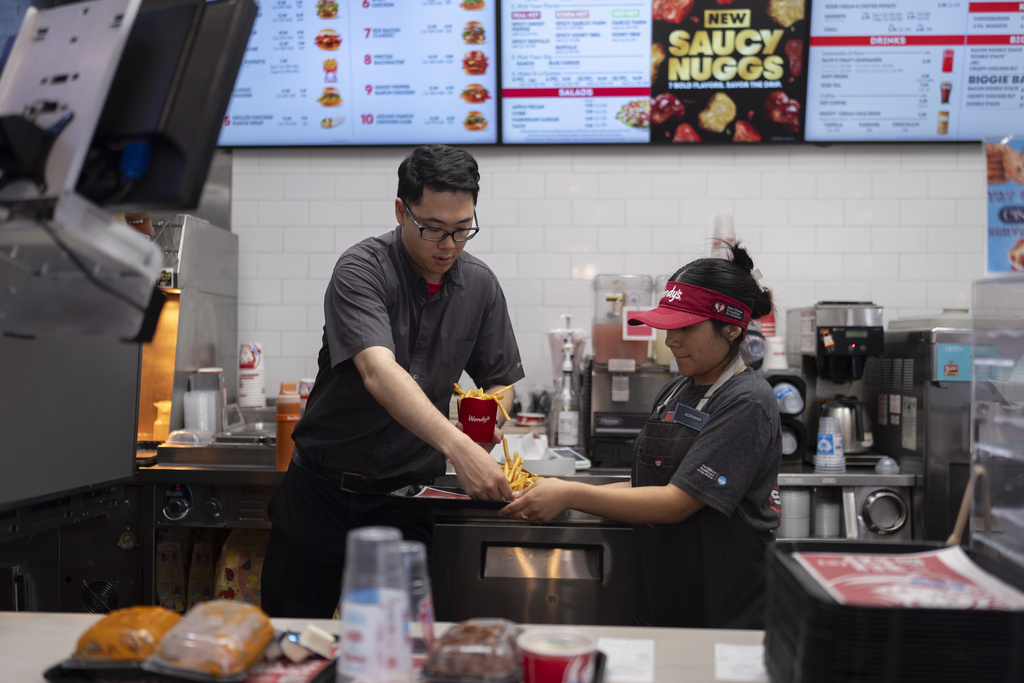 FILE - Lawrence Cheng, left, whose family owns seven Wendy's locations south of Los Angeles, works with part-time employee Adriana Ruiz at his Wendy's restaurant in Fountain Valley, Calif., June 20, 2024. (AP Photo/Jae C. Hong,File)