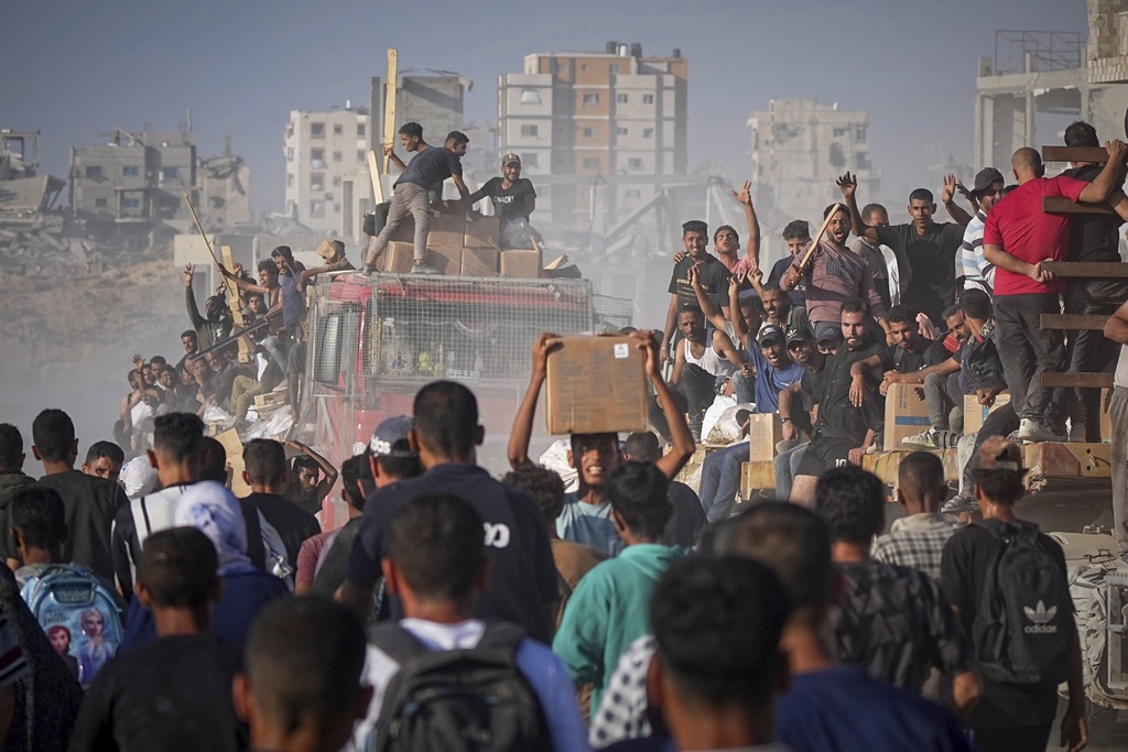 Palestinians ride on a truck loaded with food and humanitarian aid from the World Food Program, after it arrived in the northern Gaza Strip, June 16, 2025. (AP Photo/Jehad Alshrafi)