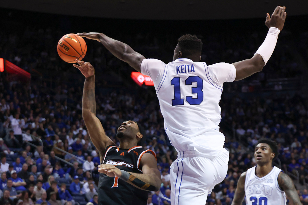 BYU center Keba Keita (13) blocks the shot of Pacific guard Justin Rochelin (1) during the second half of an NCAA basketball game, Tuesday, Dec. 16, 2025, in Provo, Utah. (AP Photo/Rob Gray)