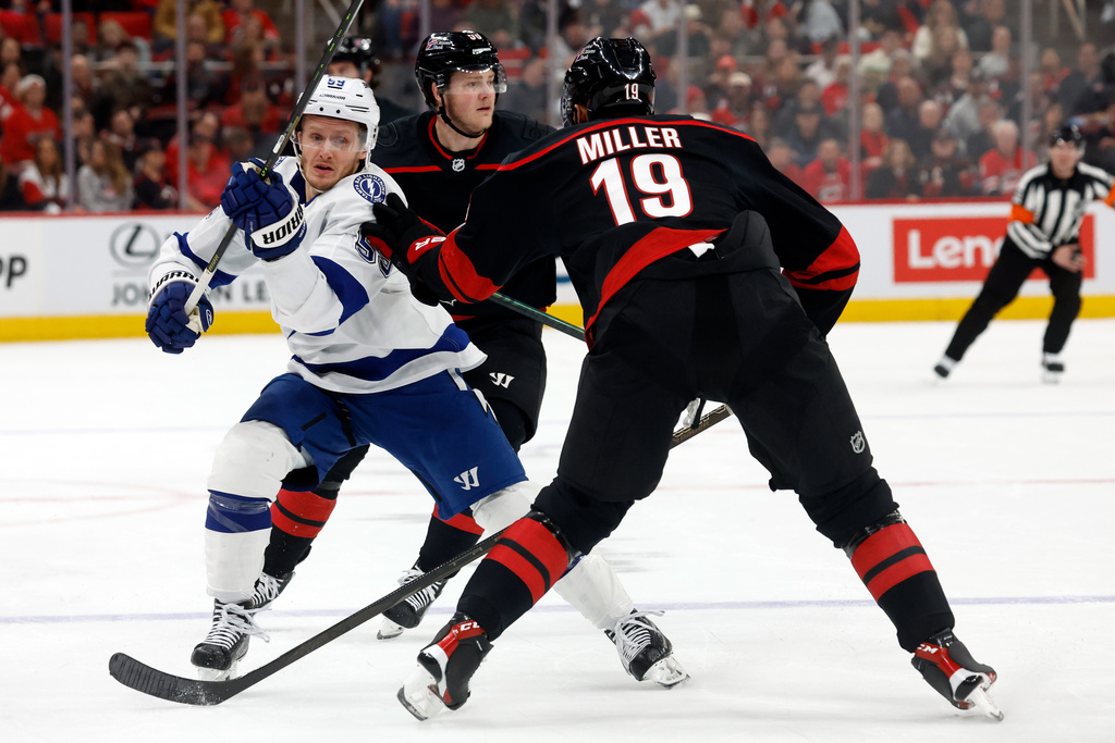 Tampa Bay Lightning's Jake Guentzel (59) tangles with Carolina Hurricanes' K'andre Miller (19) during the first period of an NHL hockey game in Raleigh, N.C., Thursday, Feb. 26, 2026. (AP Photo/Karl DeBlaker)