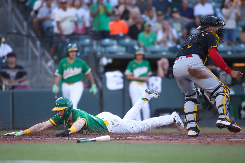 Athletics' Henry Bolte, left, slides into home plate and scores during the second inning of a baseball game against the Pittsburgh Pirates, Monday, June 15, 2026, in West Sacramento, Calif. (AP Photo/Scott Marshall)