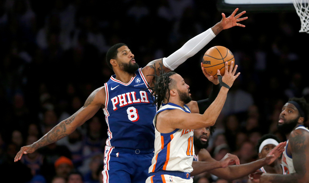 Philadelphia 76ers forward Paul George, left, defends the shot of New York Knicks guard Jalen Brunson during the second half of an NBA basketball game, Saturday, Jan. 3, 2026, in New York. (AP Photo/John Munson)