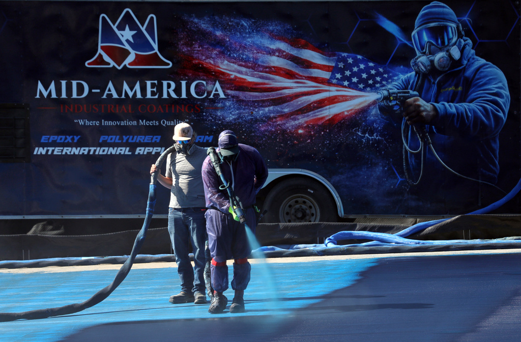 A blue protective coating, as part of a renovation project to the Lincoln Memorial Reflecting Pool, is seen being sprayed, Friday, May 29, 2026, in Washington. (AP Photo/Rahmat Gul)
