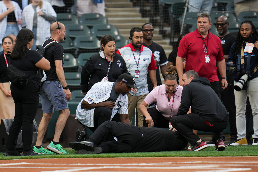People tend to a man who collapsed while singing "Lift Every Voice and Sing" before a baseball game between the Tampa Bay Rays and Chicago White Sox, Wednesday, April 15, 2026, in Chicago. (AP Photo/Erin Hooley) CORRECTION: Corrects from Life to Lift