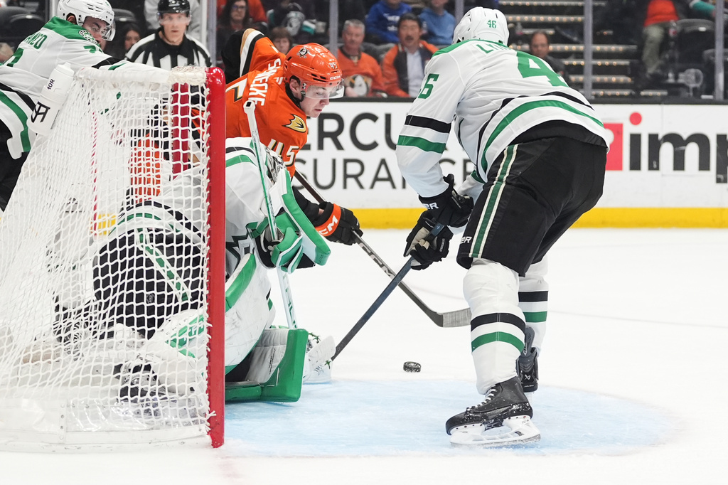 Anaheim Ducks right wing Beckett Sennecke, behind, scores a goal as Dallas Stars goaltender Casey DeSmith, left, and defenseman Ilya Lyubushkin defend during the third period of an NHL hockey game Tuesday, Jan. 13, 2026, in Anaheim, Calif. (AP Photo/Gregory Bull)