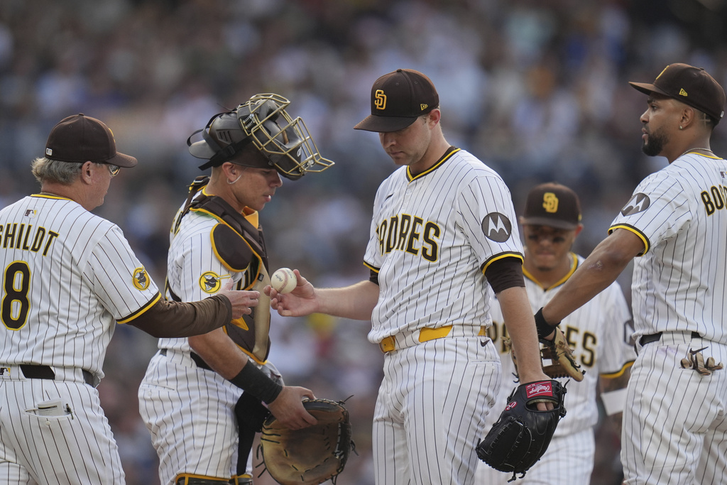San Diego Padres starting pitcher Michael King, center, hands the ball to manager Mike Shildt (8) as he exits during the third inning of a baseball game against the Boston Red Sox Saturday, Aug. 9, 2025, in San Diego. (AP Photo/Gregory Bull)