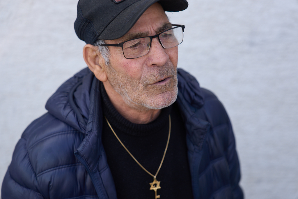 Avraham Golan waits next to a bomb shelter as precaution form incoming Iranian and Hezbollah missile strikes near closed shops in Kiryat Shmona, northern Israel, on the border with Lebanon, Monday, March 16, 2026. (AP Photo/Ariel Schalit)