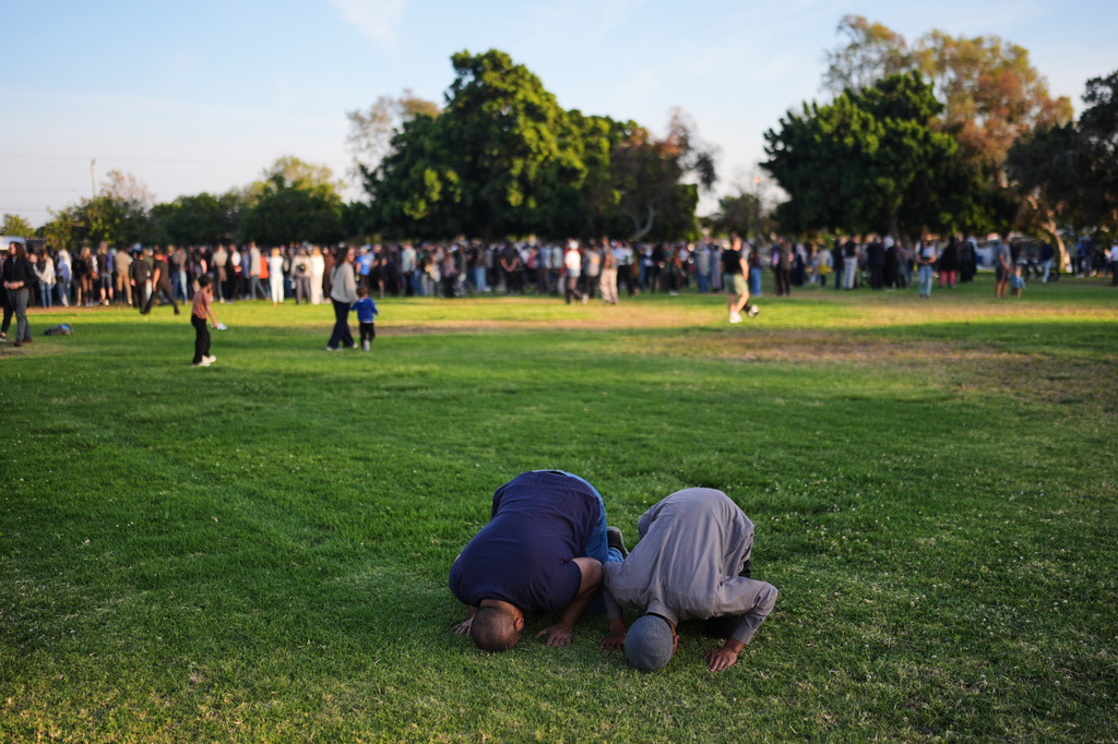 Two people pray during a vigil, the day after a shooting, outside of the Islamic Center of San Diego, Tuesday, May 19, 2026, in San Diego. (AP Photo/Jae C. Hong)