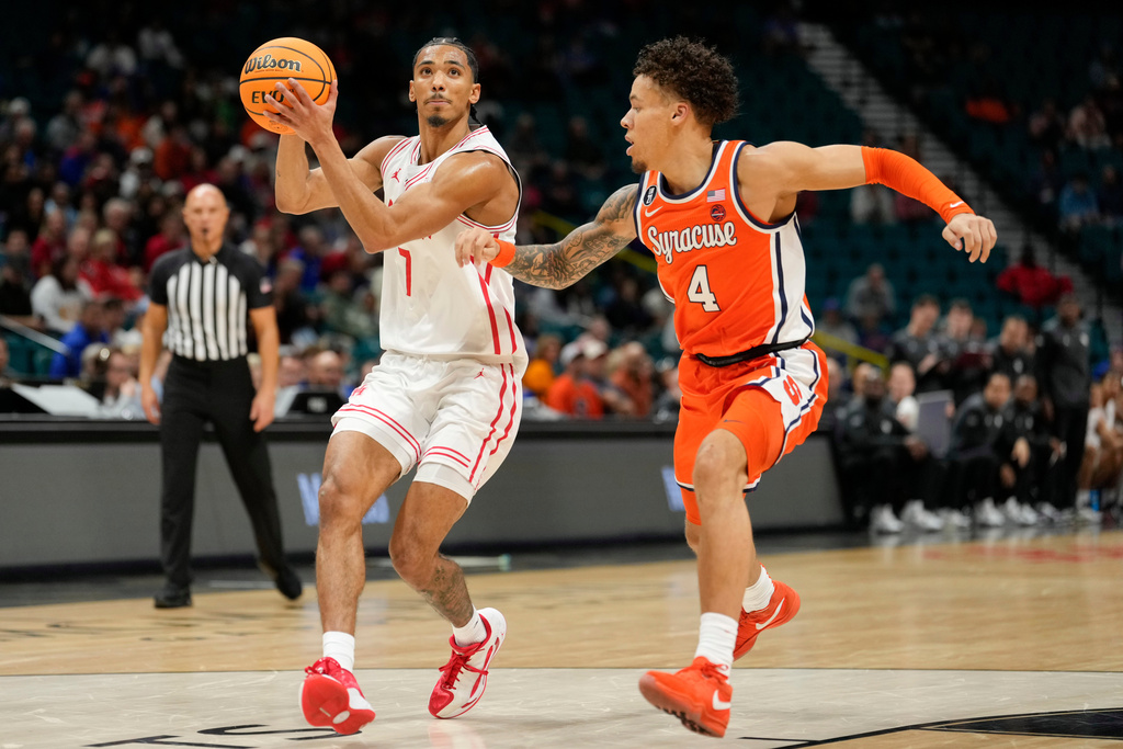 Houston guard Milos Uzan (7) drives the ball against Syracuse guard Nate Kingz (4) during the first half of an NCAA college basketball game, Monday, Nov. 24, 2025, in Las Vegas. (AP Photo/Lucas Peltier)