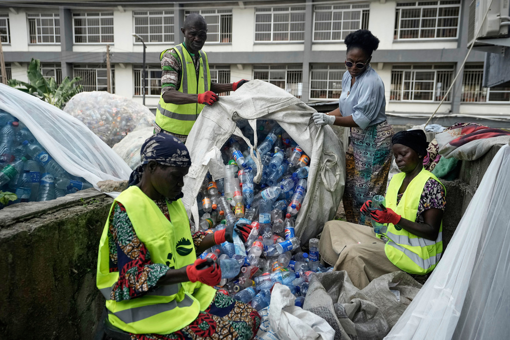 Omoh Alokwe, back right, co-founder of Street Waste Company, along with workers sorts out different soft-drink plastic bottles at the Street Waste company in Lagos, Nigeria, Monday, Aug 11, 2025. (AP Photo/Sunday Alamba)
